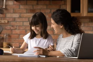 Young women homeschooling young girl 