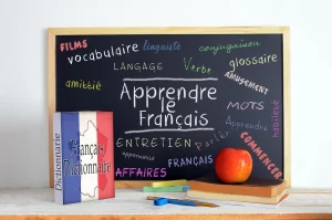 A close-up of a student's hand writing on a black board