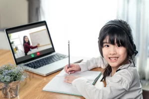 Young girl of Asian descent learning online while homeschooling