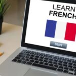 Laptop showing France national flag with learn French class start button