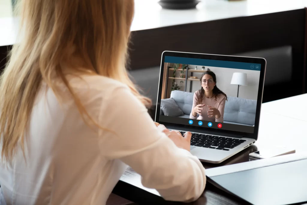 A young girl having online learning session from a female teacher