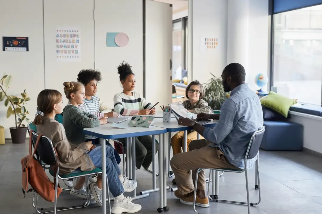 Male tutor teaching group of kids